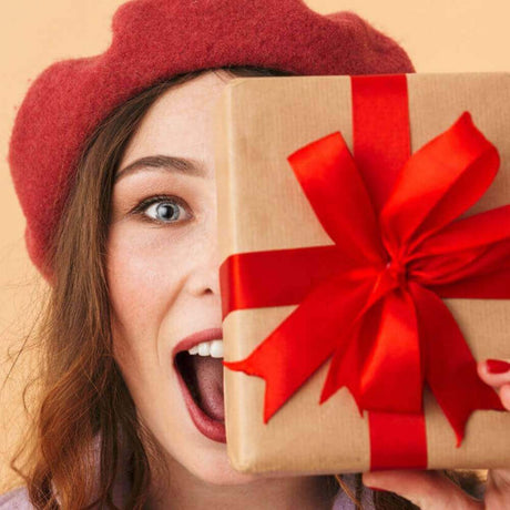Gifts for her, Woman holding a gift in front of her face
