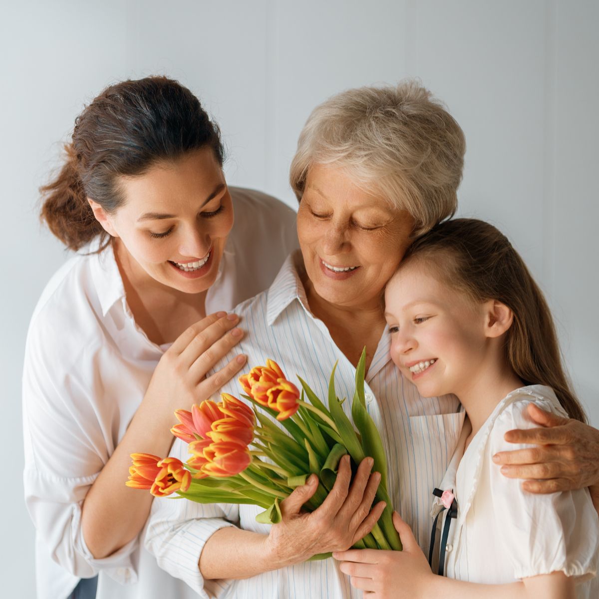 Mother, grandmother, child hugging with flowers