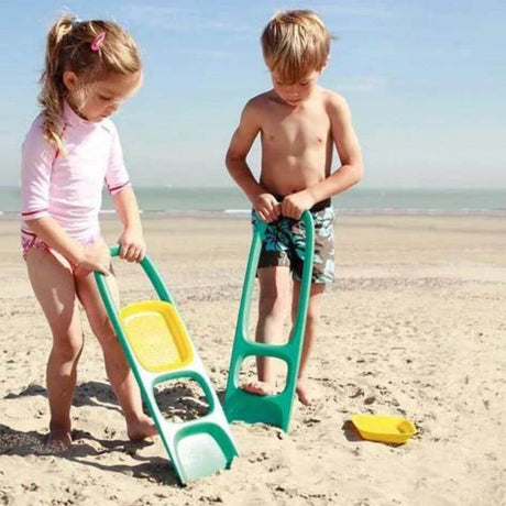 kids playing with quut shovels at the beach