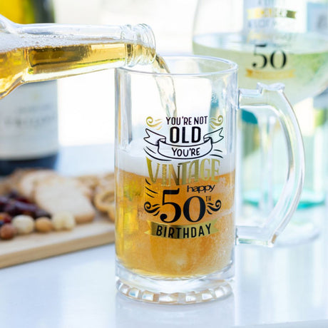 50th birthday beer glass with inscription and 50th wine glass in background