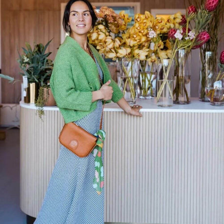 Woman Wearing green cardi and brown hand bag