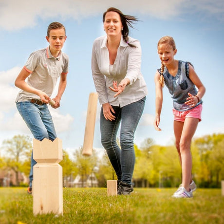 Family playing easy days kubb outdoors