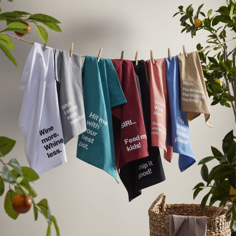 tea towels hanging on a line with fruit trees in background