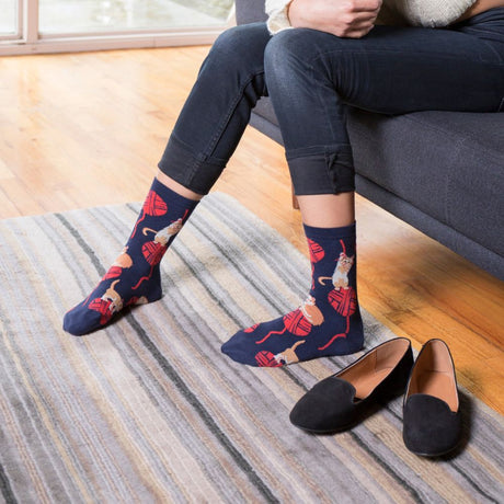 Woman on couch with sock it to me socks and slippers