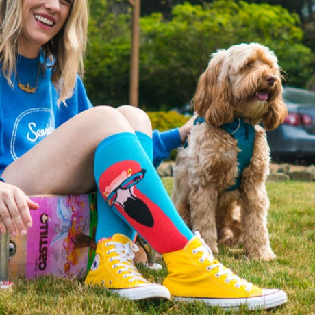 Woman at park with dow wearing knee high socks in yellow sneakers