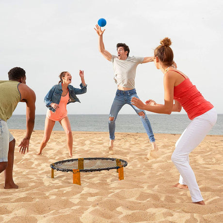 group playing on the beach with volley ball slam