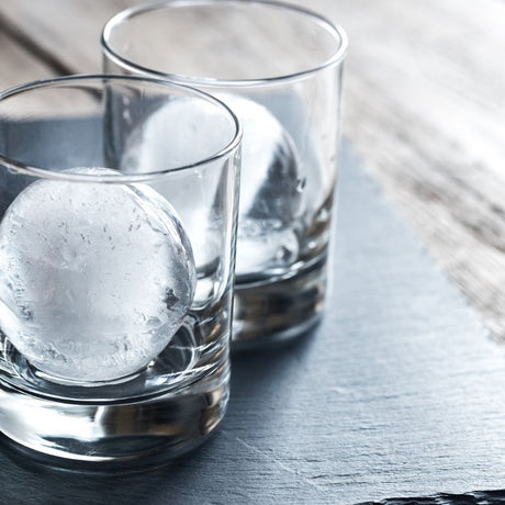 Large round ice moulds in clear glasses on table